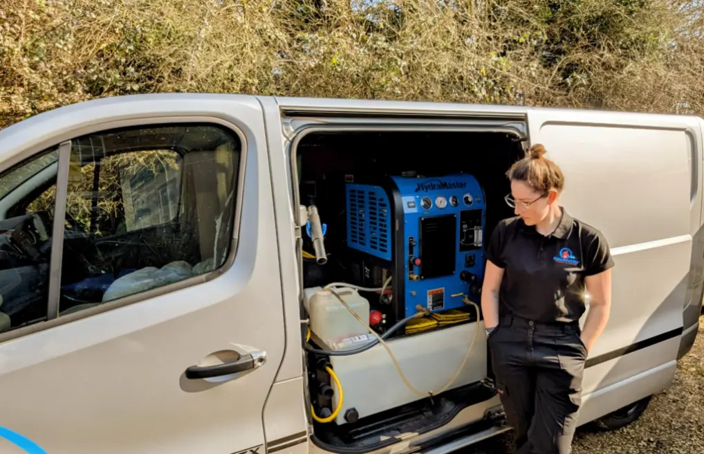 Katie owner of Daventry carpet cleaning standing by her van